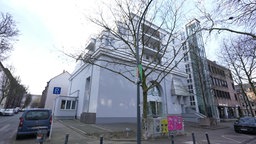 Weißes Mehrfamilienhaus an der Straßenecke