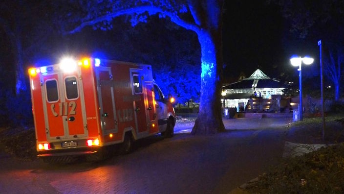 Einen Krankenwagen fährt mit Blaulicht durch die Dunkelheit im Dortmunder Stadtgarten
