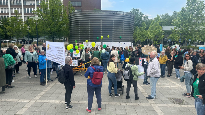 Mit Plakaten und Lufballons protestieren einige Tagesmütter in Dortmund 