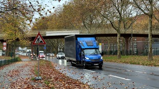 Fußgängerbrücke über die B1 mit einem Baustellenbild im Vordergrund und mehreren Farhrzeugen auf einer Fahrbahn der B1