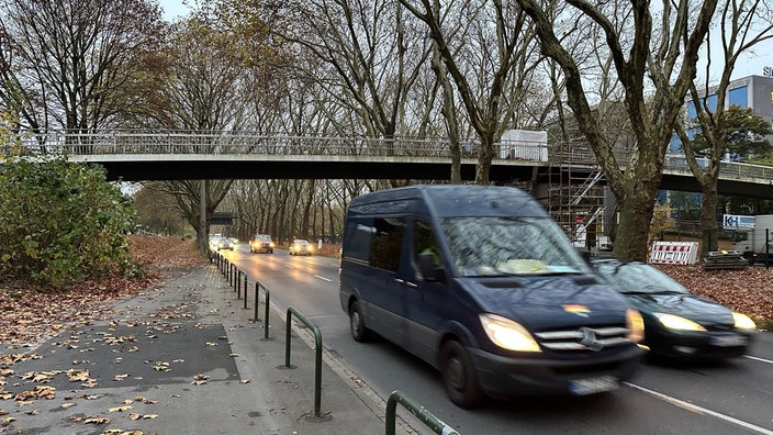 Autos und ein Lieferwagen fahren unter der Fußgängerbrücke über die B1 in Dortmund her