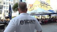 Das Bild zeigt einen Security-Mitarbeiter auf dem Alten Markt in Dortmund
