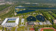 Im linken Teil des Fotos ist das Stadion des MSV Duisburg, daneben ist die Stadt von oben, mit vielen Gewässern.