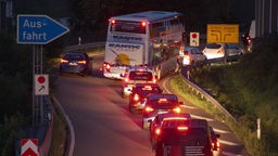 Autos stauen sich auf einer Autobahn-Ausfahrt im Morgengrauen