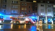 Einsatzfahrzeuge der Feuerwehr vor einem Wohnungsbrand 