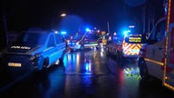 Mehrere Rettungswagen stehen nachts auf der Straße. 