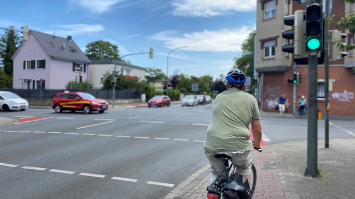 Radfahrer und Autos an einer Kreuzung in Hamm. Die Ampel zeigt Grün für den Radfahrer
