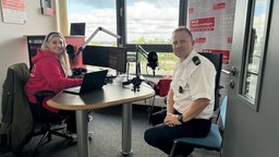 Eine Frau und ein Mann sitzen im Radiostudio