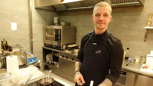 Küchenchef Tobias Weyers arbeitet in der Küche an einem Gericht