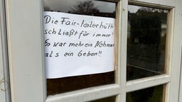 Ein beschrifteter Zettel hängt in einem Fenster