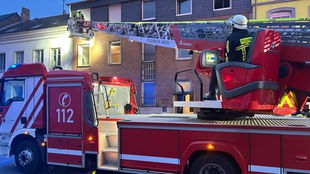 Ein Feuerwehrwagen steht vor einem Haus.