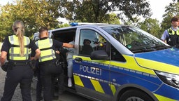 Ein Mann wird in einen Streifenwagen gesetzt