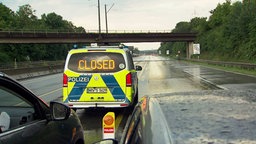 Ein Polizeiauto steht auf der A1, mit der Aufschrift 'Closed' auf der Heckscheibe