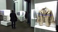 Die Schimanski-Jacke im Essener Ruhrmuseum – auf der Vitrine das Zitat "Du Idiot, hör auf mit der Scheiße"