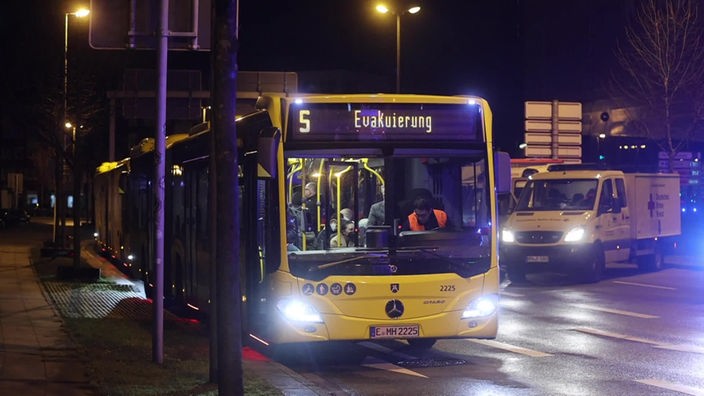 Ein Bus mit der Leuchtschrift "Evakuierung" steht bereit