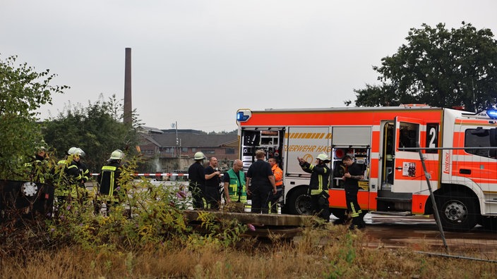 Auf dem Foto ist ein Fahrzeug der Feuerwehr und mehrere Einsatzkräfte zu sehen