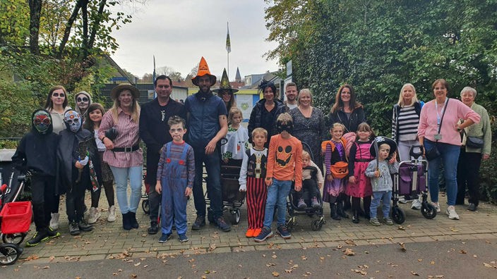 Gruppe verkleideter Kind und Erwachsener zu Halloween