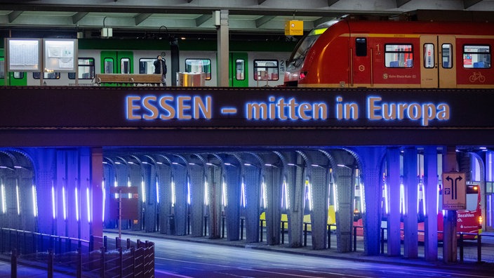 Zwei Züge stehen im Hauptbahnhof Essen, darunter die beleuchtete Straße