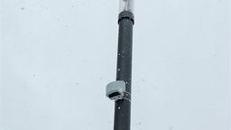 Kleines, weißes Gerät zur Radarüberwachung hängt an einem Laternenpfahl