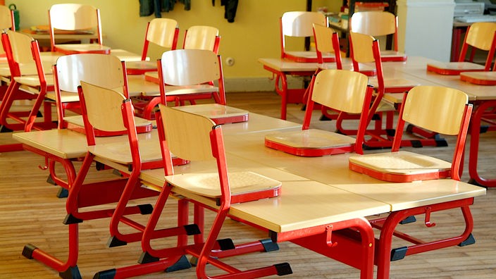 Stühle stehen in einer Klasse auf dem Tisch