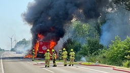 Ein Lkw steht auf der rechten Fahrbahn in Flammen. 