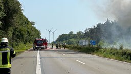 Feuerwehrkräfte löschen einen brennenden Lkw auf der A 57