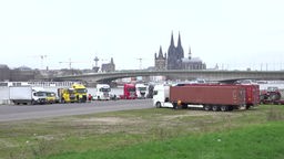 Lkw versammeln sich am Rhein in Köln.