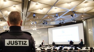 Ein Justizbeamter beobachtet in Düsseldorf die Besichtigung des Verhandlungssaals für den bevorstehenden Loveparade Prozess.