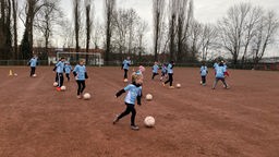 Mädchen trainieren mit einem Ball auf dem Fußballplatz