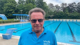 Michael Rump, Leiter des Freibades Bochum-Hofstede - mit Schwimmbecken im Hintergrund