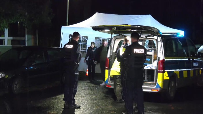 In Oberhausen ist ein Mann erstochen worden. Das Bild zeigt den Tatort, über dem ein weißes Zelt steht. Drumherum stehen Polizisten und Einsatzfahrzeuge