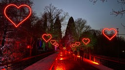 Rote Leuchtherzen entlang einer Brücke