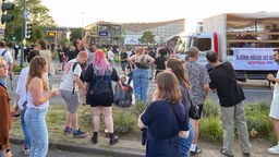 Demo-Teilnehmende stehen vor der Grugahalle in Essen