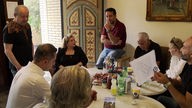 In einem Essener Café diskutieren Syrer und Libanesinnen sowie Libanesen gemeinsam die aktuelle Clankriminalität im Ruhrgebiet