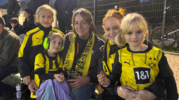 Zwei Dortmund-Fans posieren mit ihren Kindern