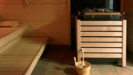 Innenraum einer Sauna mit Kohle und Aufgusseimer