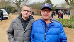 Zwei Schalke-Fans bei der Umbettung von Libuda auf dem Weg zum Grab
