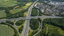 Auf dem Foto ist das Westhofener Autobahnkreuz aus einer Vogelperspektive. Flankiert wird es von Schwerte-Westhofen und Waldgebieten.