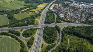 Auf dem Foto ist das Westhofener Autobahnkreuz aus einer Vogelperspektive. Flankiert wird es von Schwerte-Westhofen und Waldgebieten.