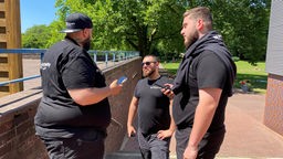 Drei Security-Mitarbeiter unterhalten sich im Gladbecker Freibad 