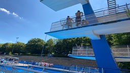 Jugendliche auf einem Sprungturm im Schwimmbad