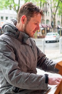 Ein Mann sitzt an einem Klavier in der Innenstadt und spielt. 