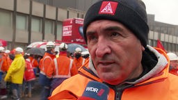 Ali Güzel in orangener Warnweste im Gespräch mit dem WDR