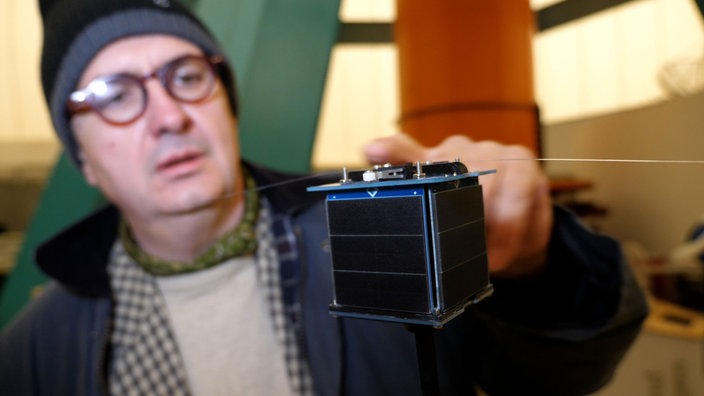 Der Leiter der Sternwarte Thilo Elsner mit dem Mini-Satelliten