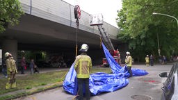 Einsatzkräfte der Feuerwehr Duisburg stehen an einer Brücke