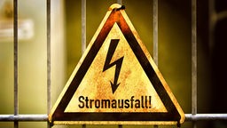 Dreieckiges Warn-Schild mit einem Blitz und darunter steht Stromausfall