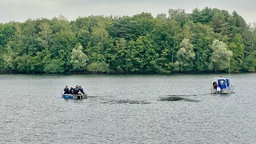 Mit zwei Polizeibooten sucht die Polizei auf dem Duisburger Wolfsee nach dem Verunglückten. 