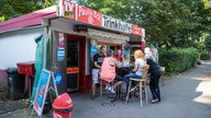 Kiosk-Besitzer Thomas Paul (l) sitzt 2018 mit Kunden vor seiner Trinkhalle