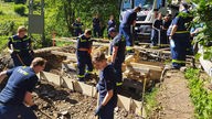 Viele Helfer des THW Hattingen beim Bau einer Brücke nach der Flutkatastrophe