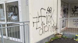Hakenkreuz mit Graffiti auf die Wand eines Containers gesprüht